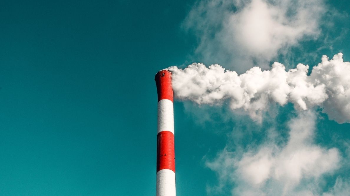 Une cheminée d'usine recrachant de la fumée blanche