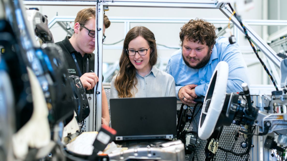 Trois jeunes gens sur une machine robotisée