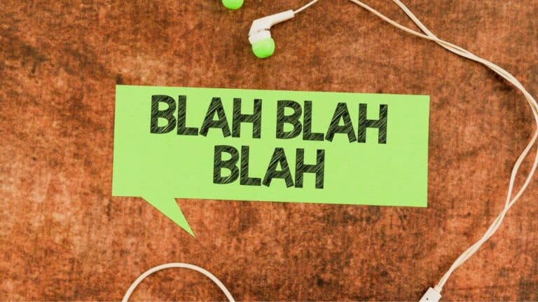 Une pancarte verte avec l'inscription "blah blah blah". Elle est entourée d'écouteurs.