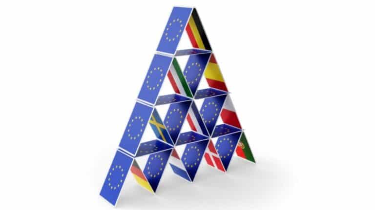 Un château de carte avec d'un coté le drapeau de l'UE et de l'autre ceux des pays membres.
