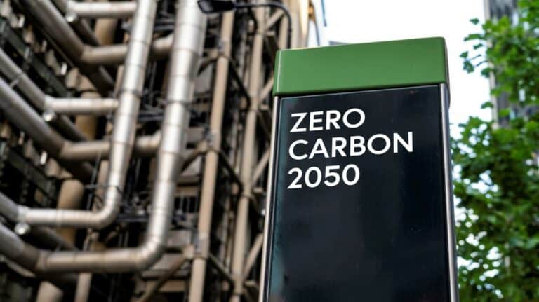 Un panneau marqué "ZERO CARBON 2050" devant un site industriel