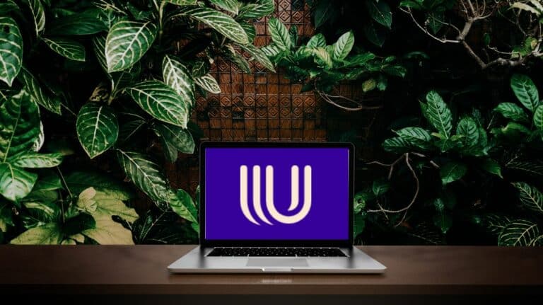 Un ordinateur avec le logo d'Umiami devant un mur de feuilles