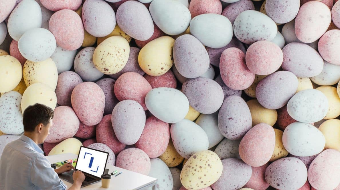 Un homme travaillant sur son ordinateur devant des oeufs de Pâques