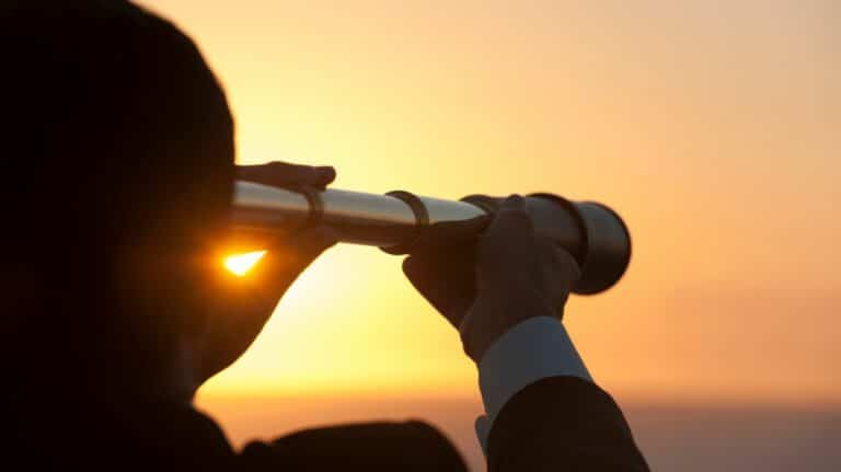 Une personne regardant un coucher de soleil à travers une longue vue